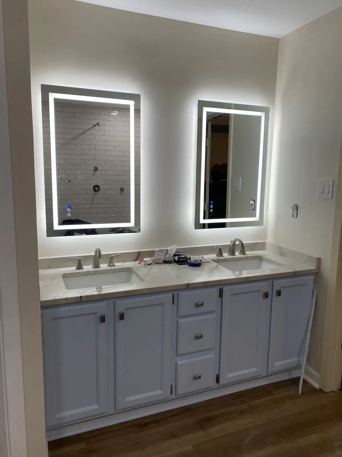 Double vanity with marble-look top and backlit LED mirrors