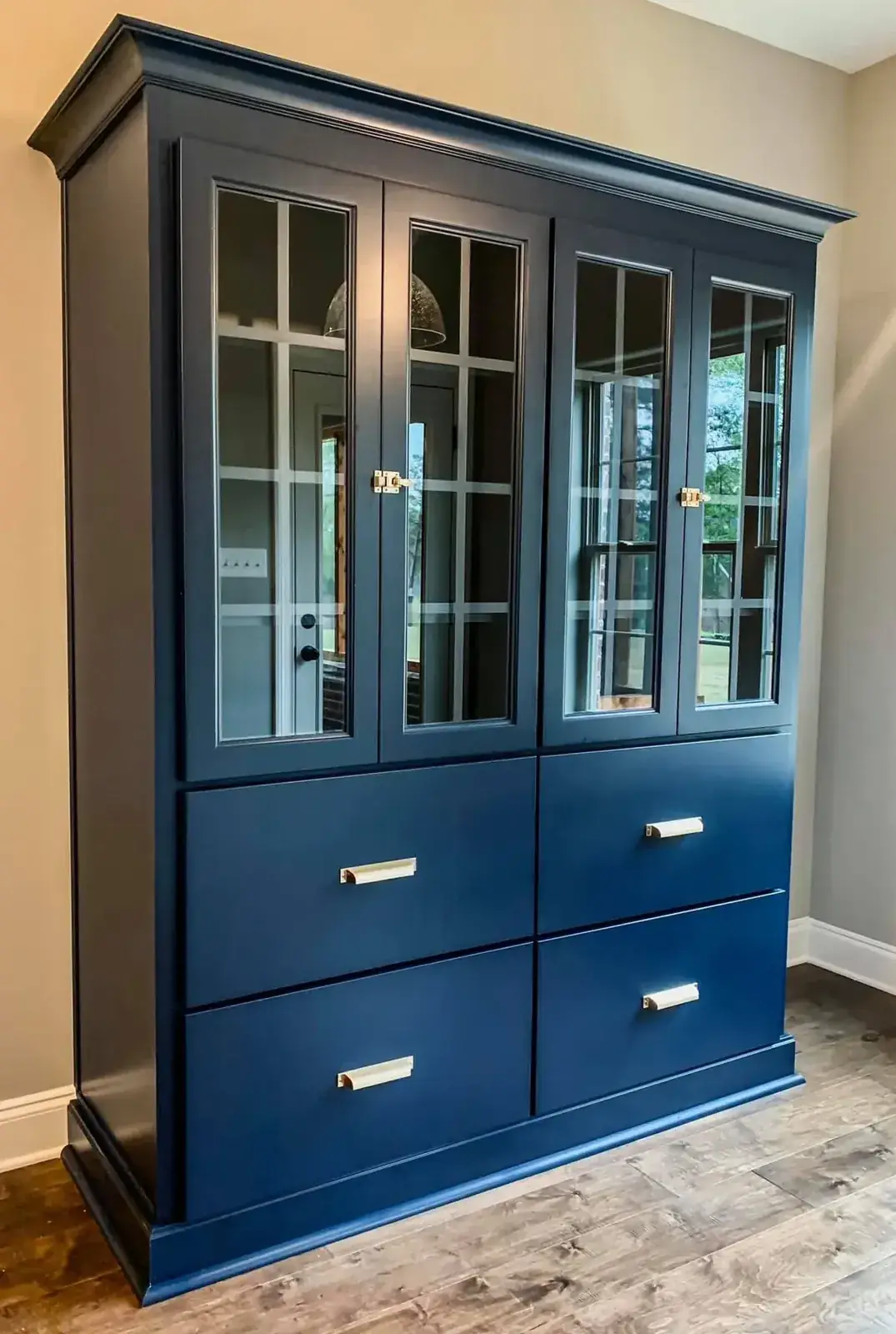 Custom navy china hutch with glass doors, brass latches and wide drawers